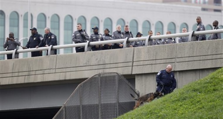 Law enforcement officers search for evidence along the I-395 expressway adjacent to the Pentagon, on Oct. 19. Authorities now say that shots fired Oct. 18 at the National Museum of the Marine Corps in Triangle, Virginia, and on Oct. 19 the Pentagon in Arlington, Virginia, have been linked to the same firearm.